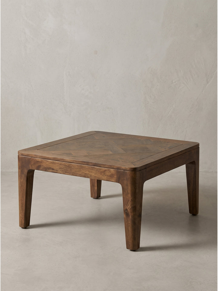 Freigestellter Couchtisch 60x60x32 cm aus handverarbeitetem Mango-Massivholz im tiefen Walnuss-Farbton schräg von vorn fotografiert._