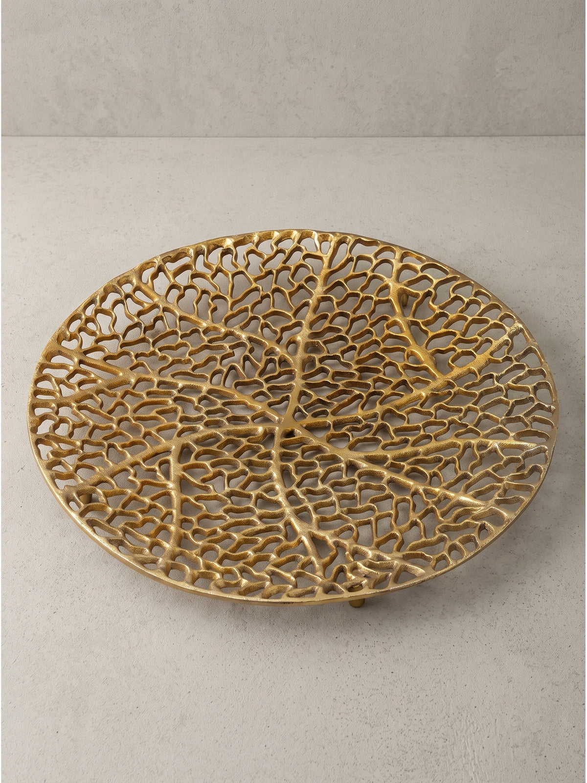 Moderne Metallschale 44x44x4 cm in goldener Ausführung mit filigranem Design von der Seite betrachtet_