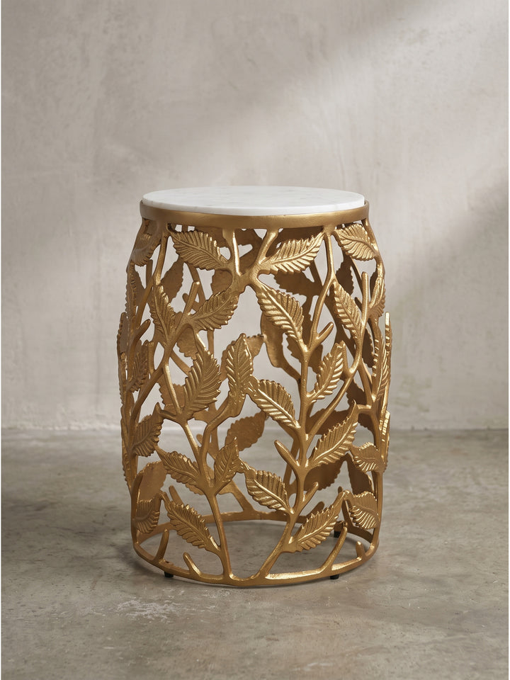 Der handgefertigte Beistelltisch präsentiert sich in der Frontalansicht mit seinem organischen Aluminiumgestell in Gold und der strahlend weißen Marmorplatte in reiner, zeitloser Eleganz._