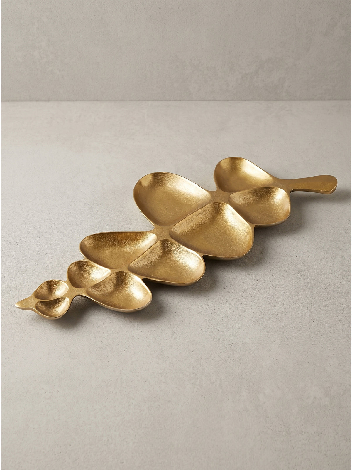 Moderne Dekoschale in Blattform Gold 60,5x17,5x3 cm aus robustem Aluminium auf weißem Hintergrund_