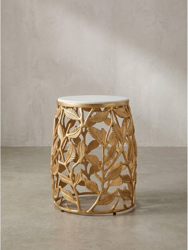 Aus dem schrägen Winkel wird die bauchige Silhouette des 46 cm hohen Tisches deutlich, wobei die kunstvoll durchbrochenen floralen Metallelemente eine beeindruckende optische Leichtigkeit erzeugen._