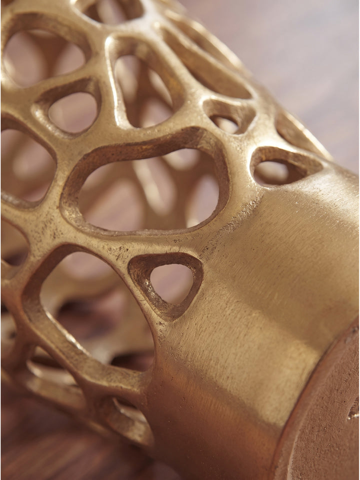 Nahaufnahme der filigranen Gitterstruktur der handgefertigten Aluminiumvase in Gold mit feinem metallischen Glanz und subtilem Lichtspiel_