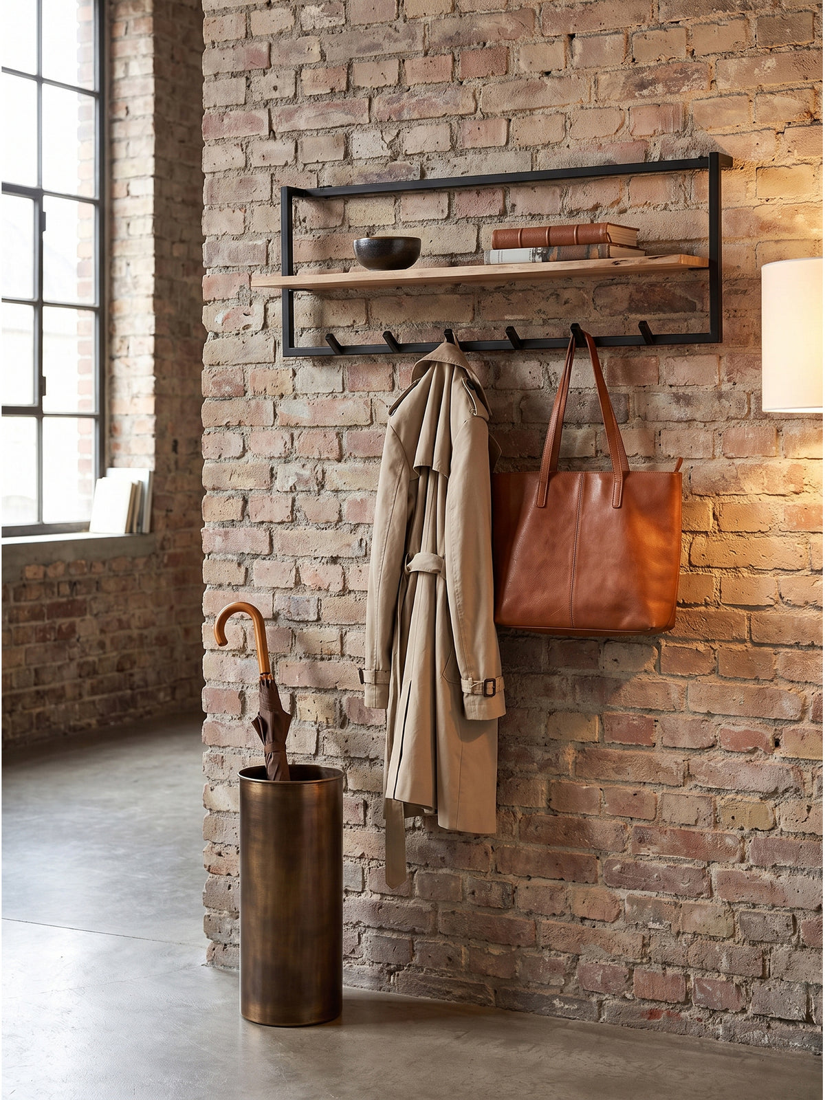 Eingangsbereich mit einer Garderobe im Industrial-Stil, einem beigen Trenchcoat an den Haken und Keramik auf der Ablage.