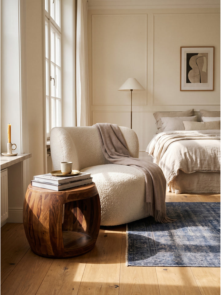 Runder Beistelltisch aus Sheesham Massivholz 50x50x40 cm im eleganten Wohnzimmer neben hellem Bouclé Sessel auf Vintage Teppich_