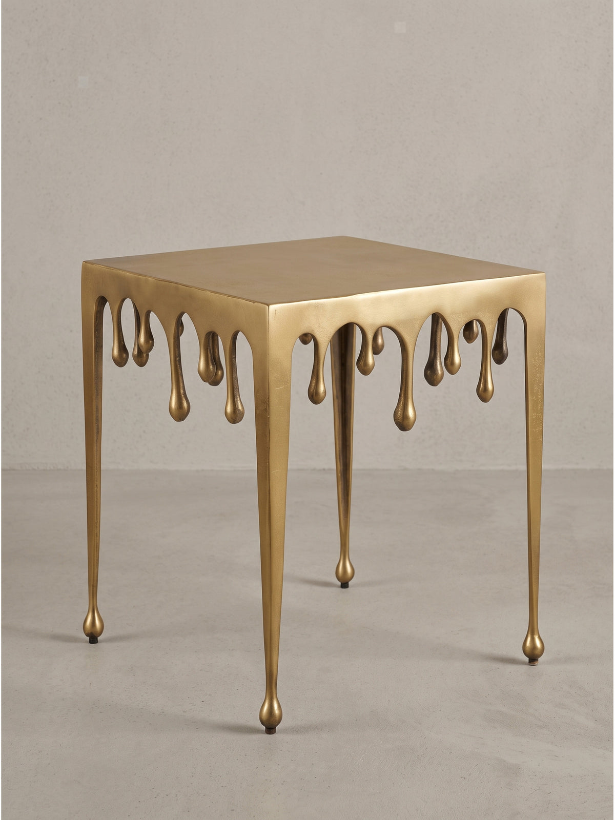 Detailaufnahme der kugelförmigen Füße mit Bodenschonern an den schlanken Beinen des goldenen Aluminiumtisches_