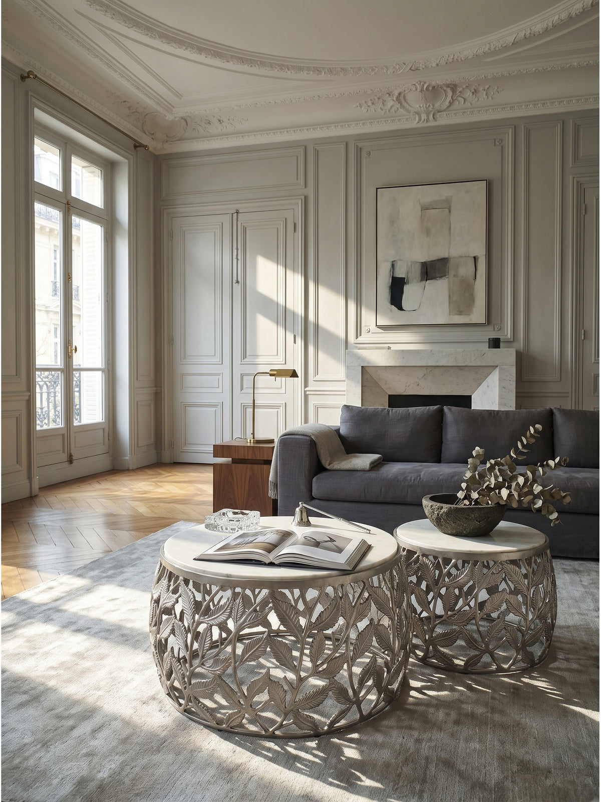 Elegantes 2er Set Couchtisch mit weißer Marmorplatte und silbernem Aluminiumgestell in Blätteroptik im klassischen Pariser Wohnzimmer auf edlem Fischgrätparkett arrangiert.