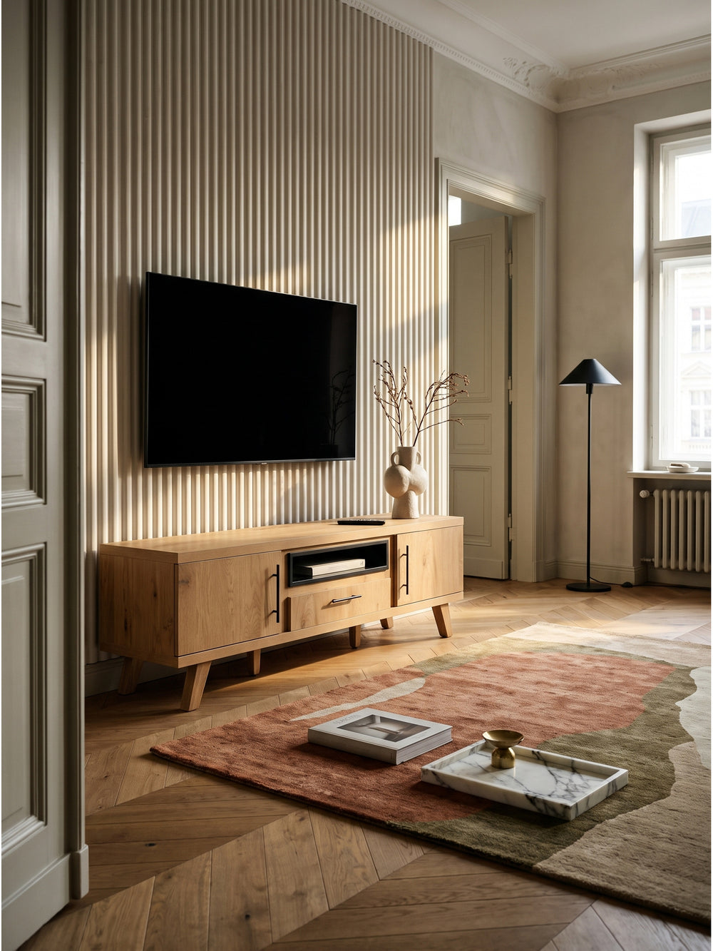 TV Lowboard in Eiche Dekor mit schwarzen Akzenten 150x40x51,8 cm im gemütlichen Wohnzimmer auf einem dicken sandfarbenen Wollteppich_