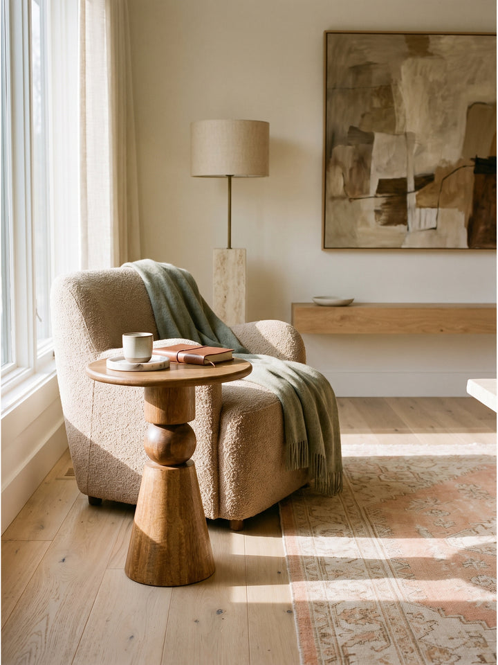 Runder Loungetisch Couchtisch Natur kombiniert mit einer handgefertigten Keramiklampe vor einer dezenten Limewash-Wand_