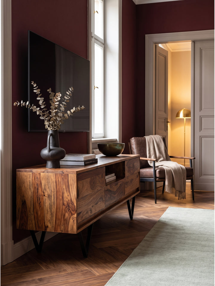 Stilvolles Wohnzimmer-Arrangement mit massiven Holz-TV-Möbel und einem hellen Leinensofa vor hohen Fenstern_