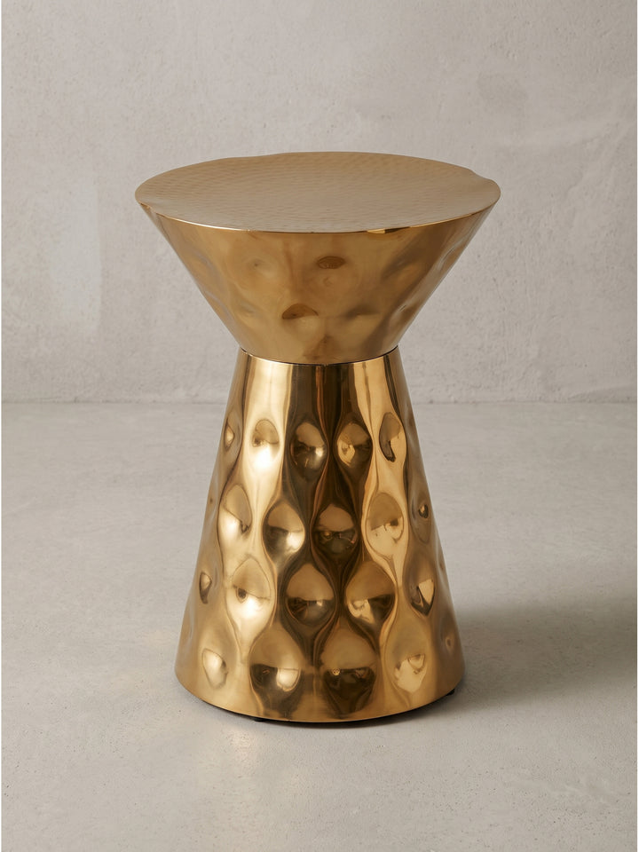 Runder Beistelltisch aus Aluminium in Gold 36x51 cm in Sanduhrform vor weißem Hintergrund mit strukturierter Oberfläche_