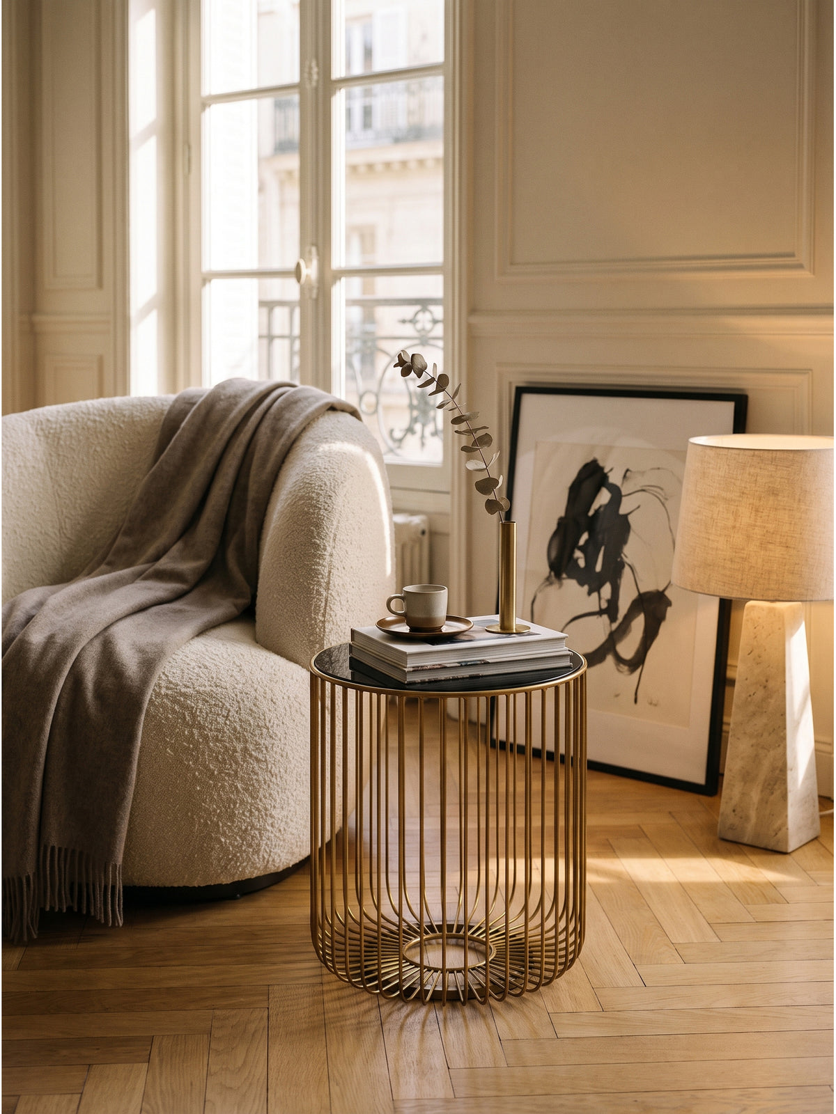 Goldener Couchtisch aus lackiertem Metall mit Architektur-Bildbänden und einer dezenten Dekoration auf der glatten Glasauflage._