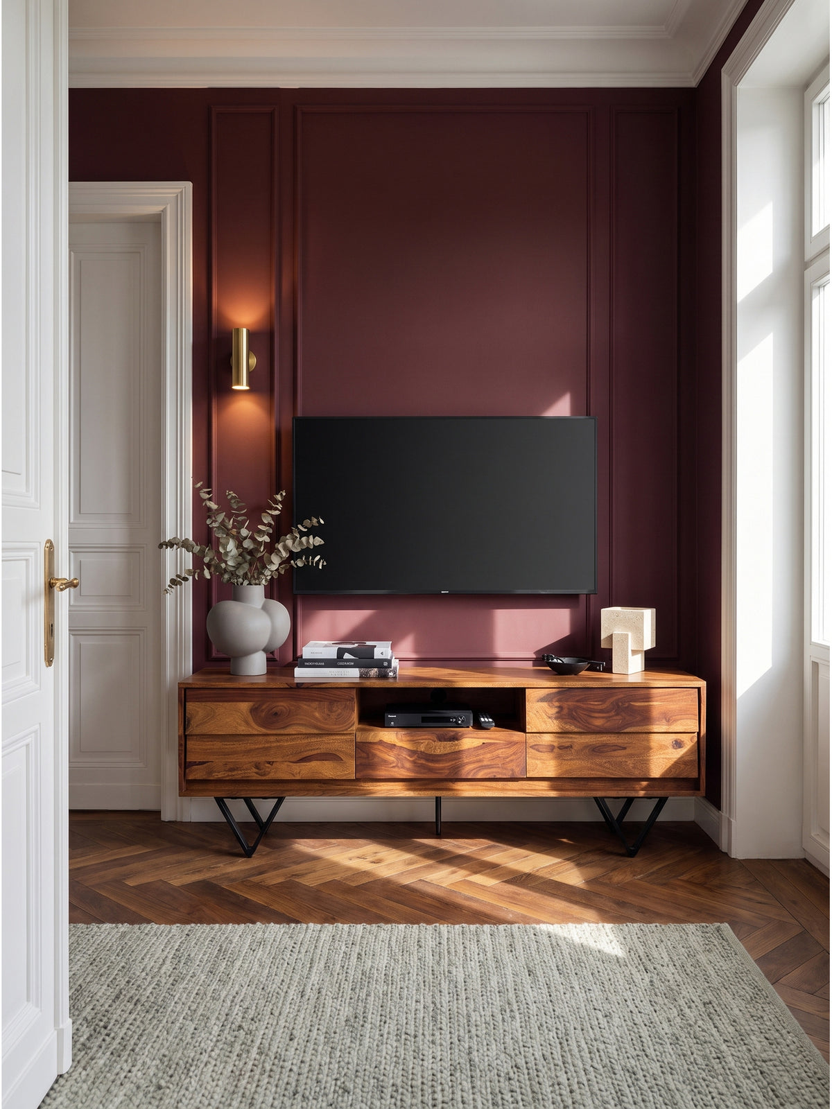 Breites TV-Lowboard aus massivem Sheesham-Holz 160x35x56 cm im eleganten Wohnzimmer vor dunkelroter Akzentwand mit Fischgrätparkett_
