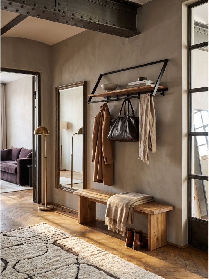 Die schwarze Metallgarderobe harmoniert perfekt mit einer Vintage-Holzbank und einem verblassten Oushak-Teppich im luxuriösen Entrée._