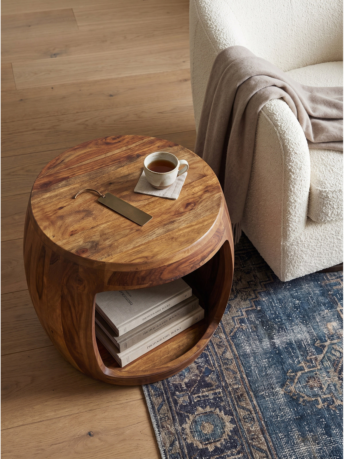 Couchtisch Holz rund mit offenem Fach von oben fotografiert im modernen Loungebereich mit Eichenparkett und Travertin Leuchte