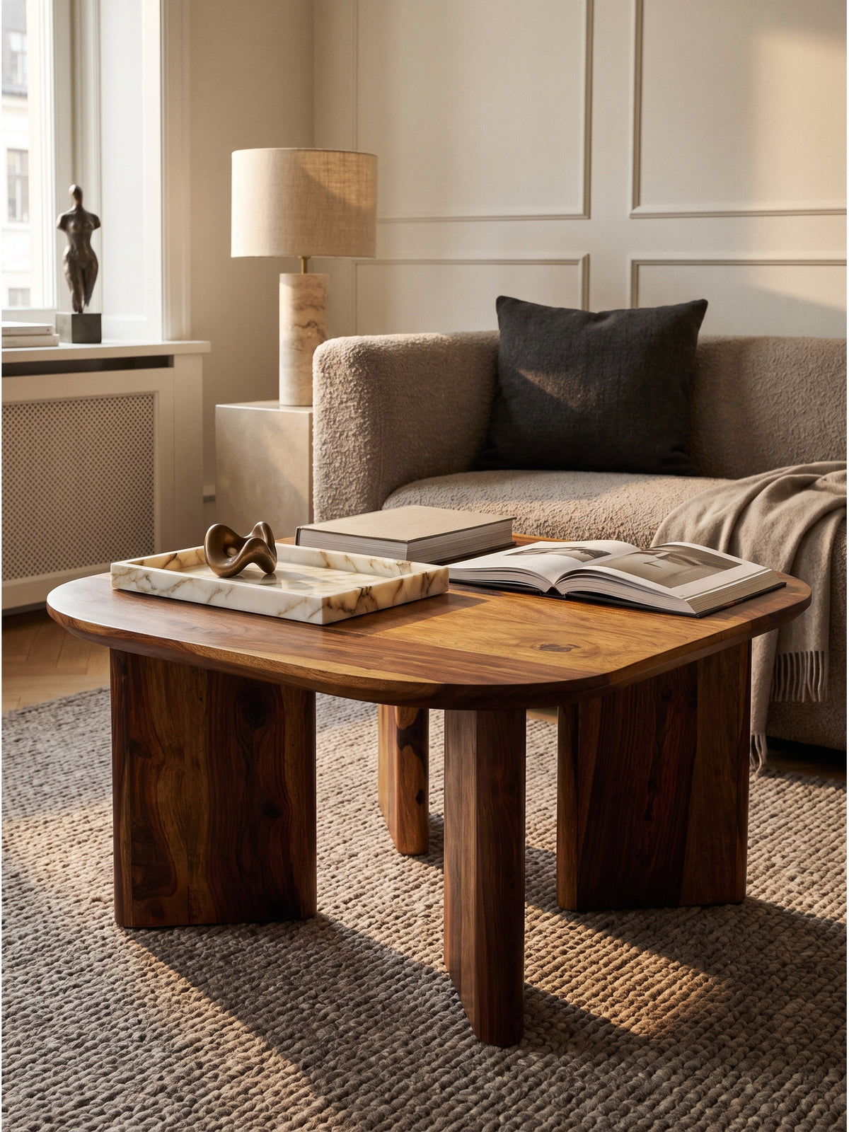 Modern designter Sofatisch aus dunkel gebeiztem Holz dekoriert mit einer minimalistischen Schale und Büchern in einem lichtdurchfluteten Raum_