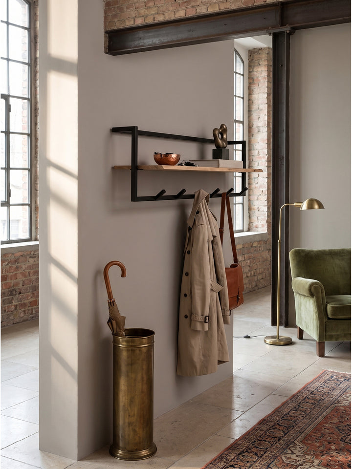 Handgefertigte Massivholz-Garderobe über einem massiven Schirmständer in einem eleganten Flur mit hohen Decken._