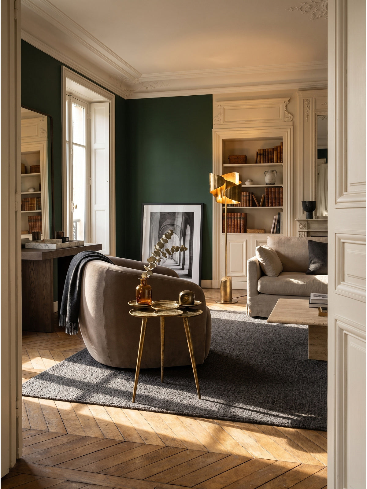 Skulpturaler Beistelltisch aus Aluminium in Gold neben einem hellen Leinesessel in einem eleganten Wohnzimmer mit Fischgrätparkett._