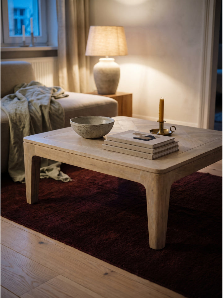 Styling eines kleinen quadratischen Wohnzimmertisches aus Holz mit wabi-sabi Keramikschale und Leinenbüchern_