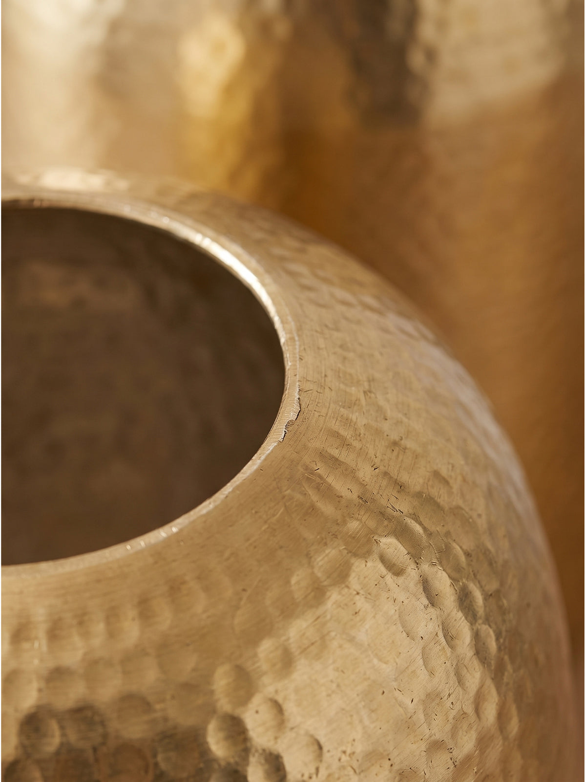 Nahaufnahme der gehämmerten Oberfläche der goldenen Aluminium-Vase mit metallischem Glanz und feinen handwerklichen Strukturdetails