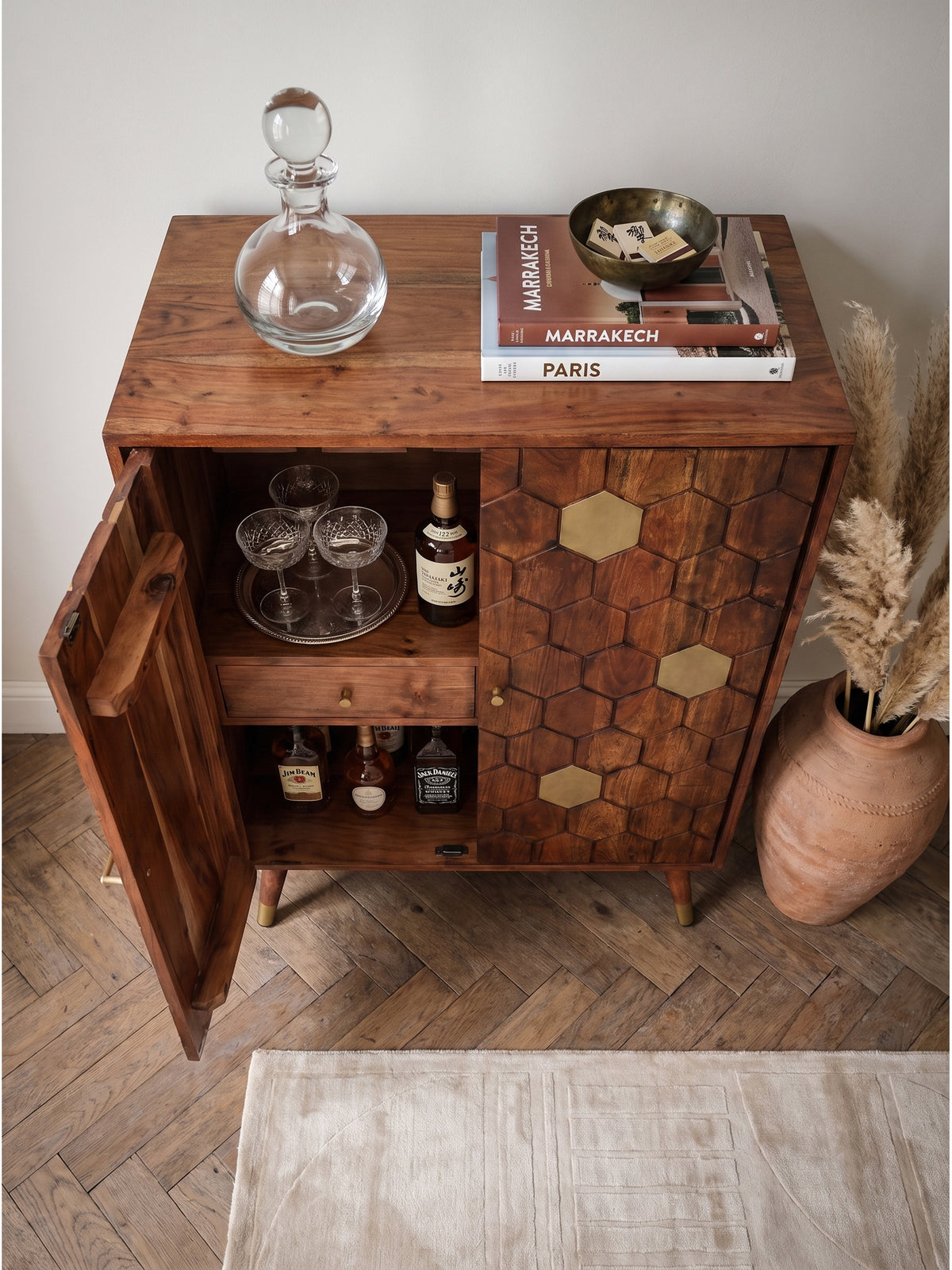 Hausbar mit markantem Wabenmuster und Messingdetails von oben betrachtet in einem eleganten Wohnbereich mit Vintage-Teppich_