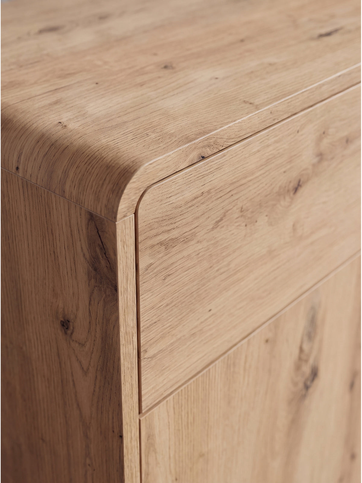 Nahaufnahme der warmen Holzmaserung des Sideboards Eiche Dekor mit grifflosem Push-to-Open-Design an Schublade
