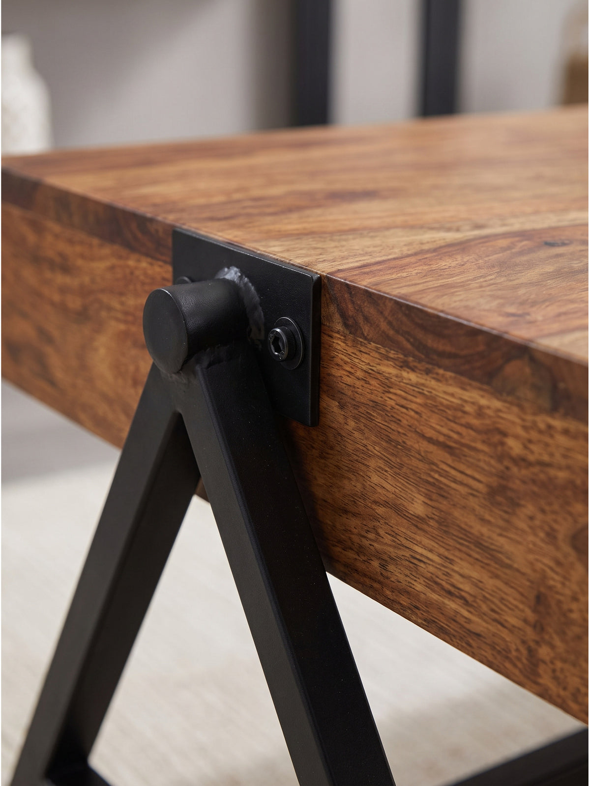 Detailaufnahme der markanten Holzmaserung des Massivholz Couchtisches, dessen warme braune Oberfläche ein matter Klarlack schützt._