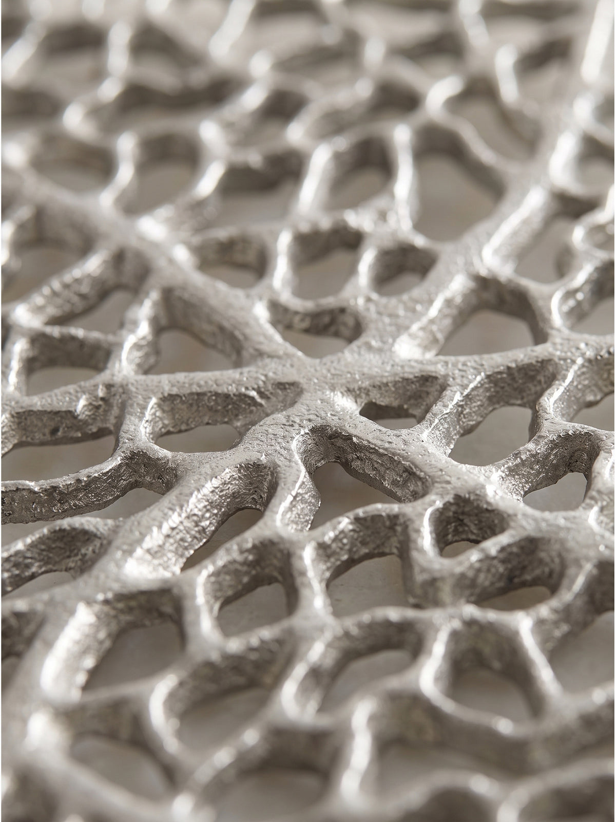 Detailaufnahme der filigranen Netz-Struktur der Dekoschale aus Metall in Silber mit sichtbarer Oberflächentextur_