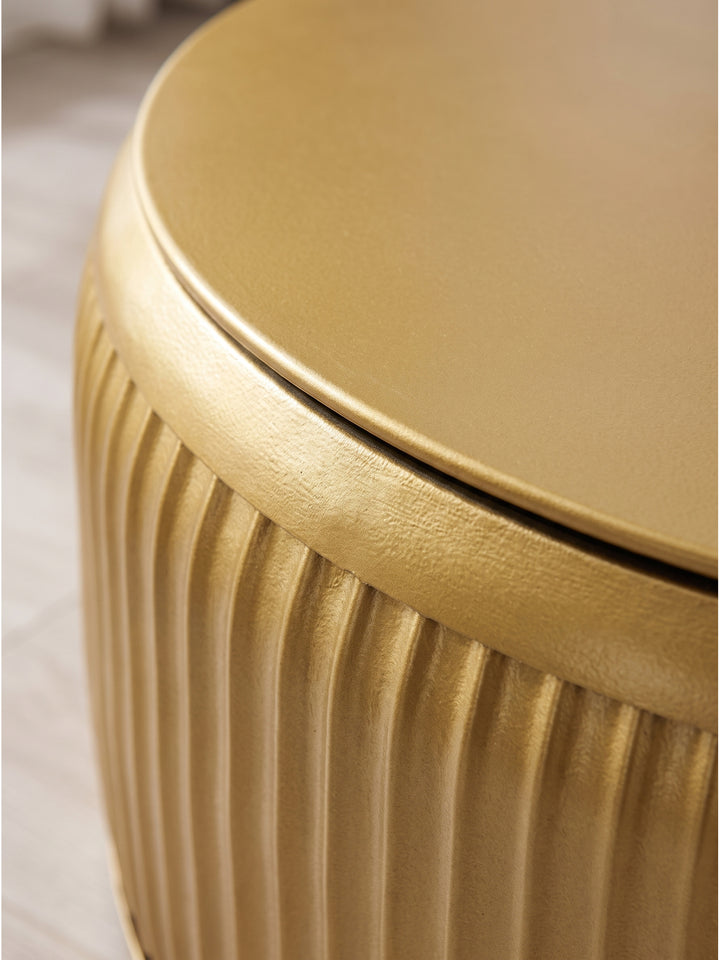 Nahaufnahme der vertikalen Rillenstruktur und der warmen goldenen Lackierung des exklusiven runden Loungetisches aus robustem Metall_