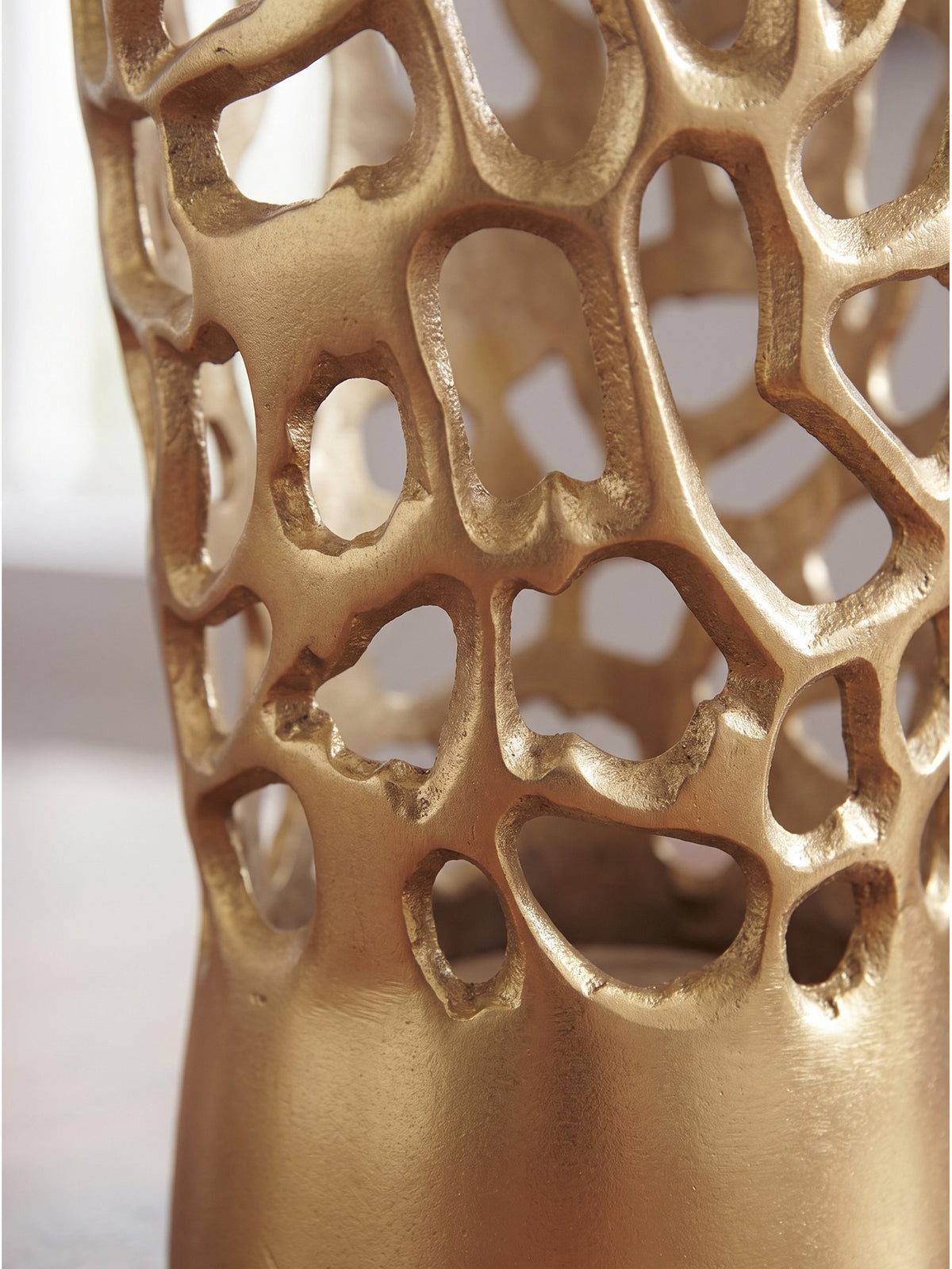Nahaufnahme der organischen Zellstruktur und handgefertigten Oberfläche der großen goldenen Aluminiumvase