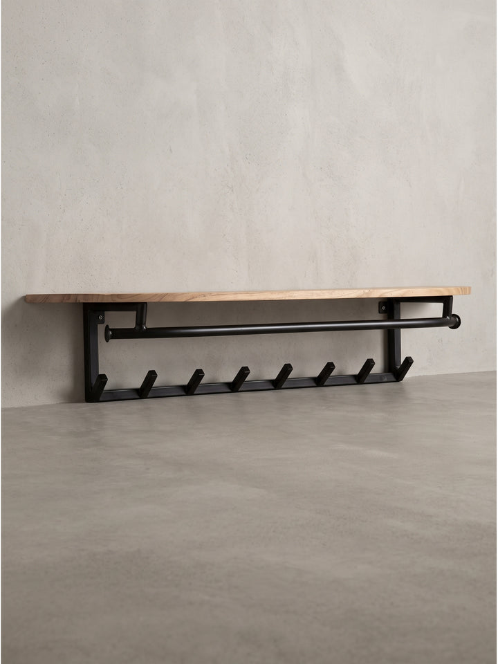 Seitenprofil der Wandgarderobe aus Akazie Massivholz und schwarzem Metall verdeutlicht die Tiefe der Ablage und die Form der Kleiderhaken_