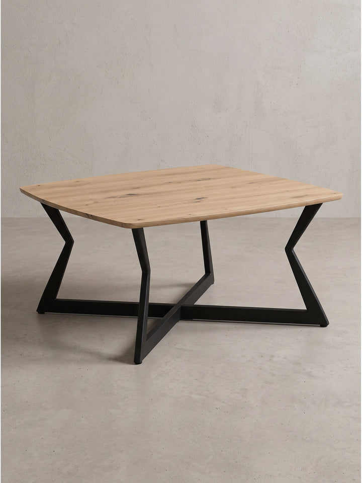 Quadratischer Couchtisch 75x75 cm mit warmer Eiche Optik und schwarzem Metallgestell in schräger Frontansicht_