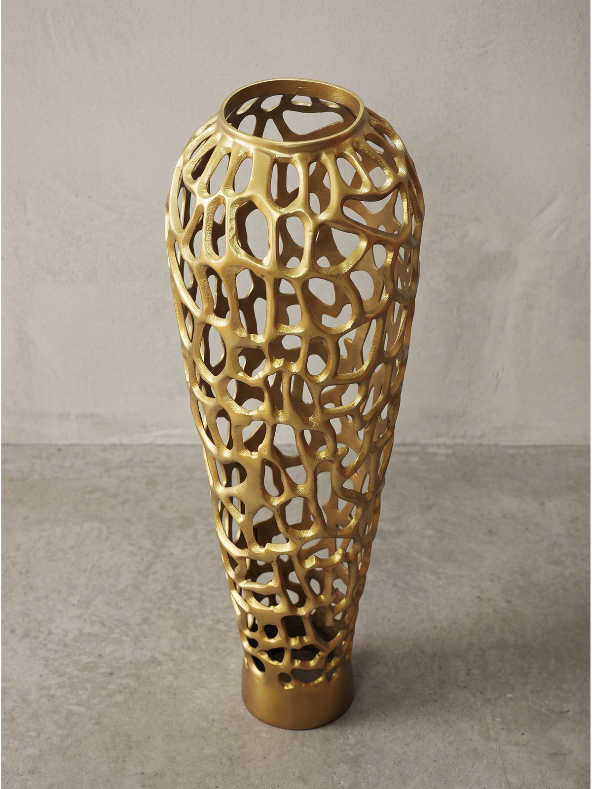 Leicht gedrehte Ansicht der durchbrochenen goldenen Metallvase mit 31 cm Durchmesser und markanter Wabenstruktur