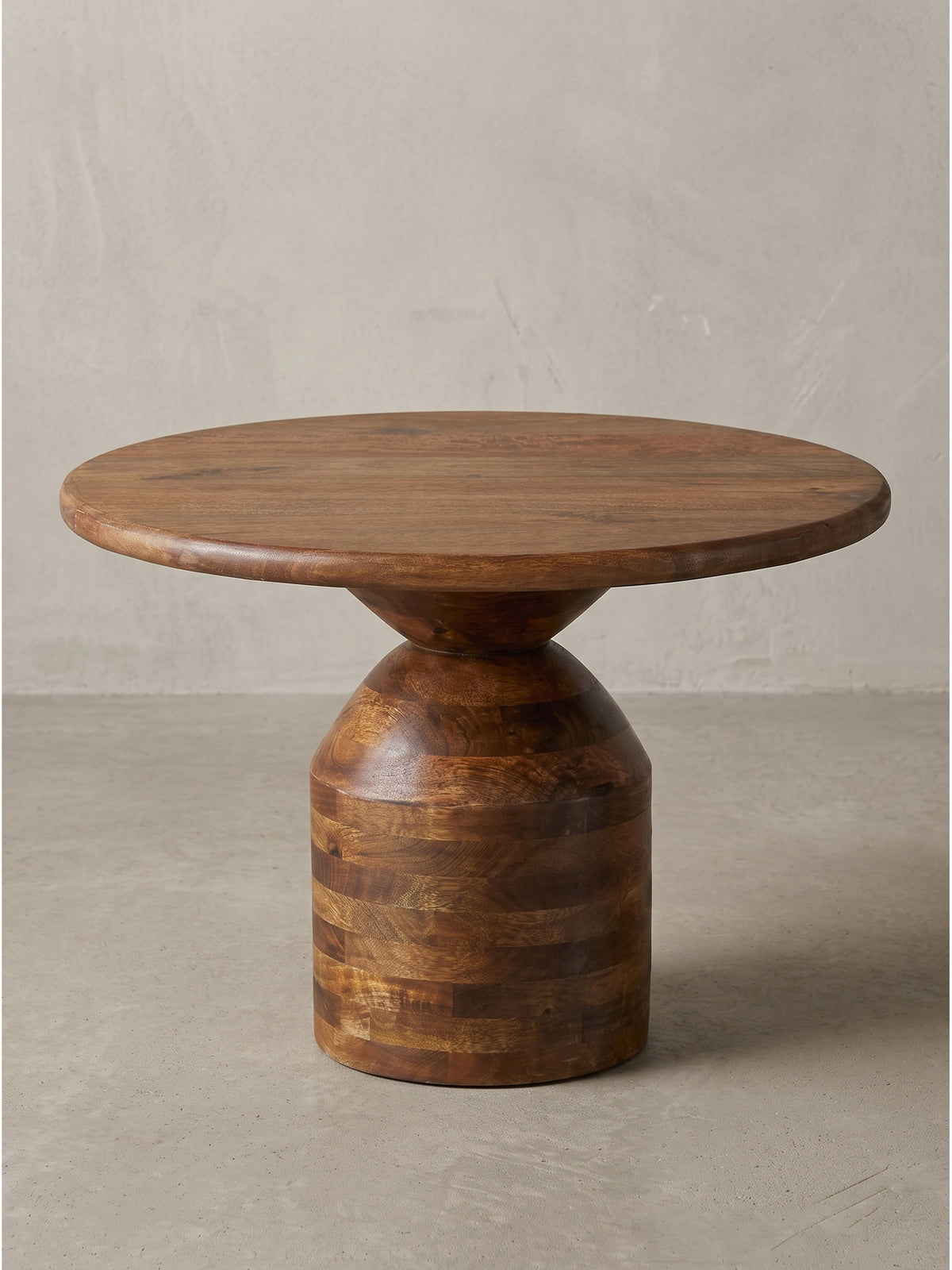 Runder Kaffeetisch im organischen Design aus naturlackiertem Mango Massivholz schräg von der Seite fotografiert vor neutralem Hintergrund_
