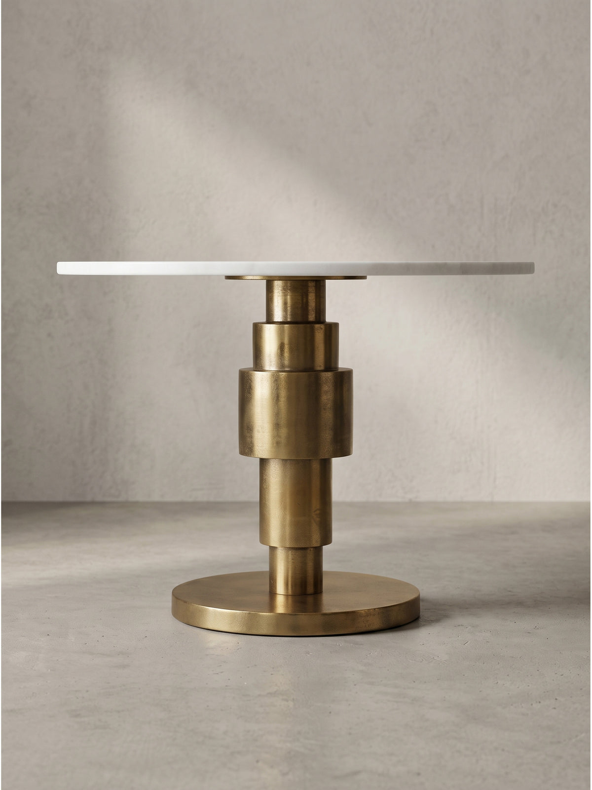 Leicht seitliche Perspektive des Art-Deco Wohnzimmertisches, die den glänzenden Aluminiumfuß und die weiße Steinplatte eindrucksvoll zeigt_