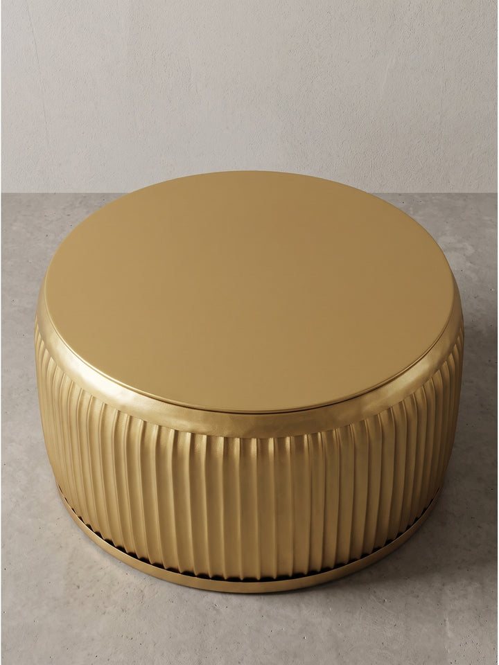 Leicht gedrehte Ansicht des goldenen Metall-Loungetisches zeigt die perfekte Zylinderform und die feine Oberflächenverarbeitung des Eisens_