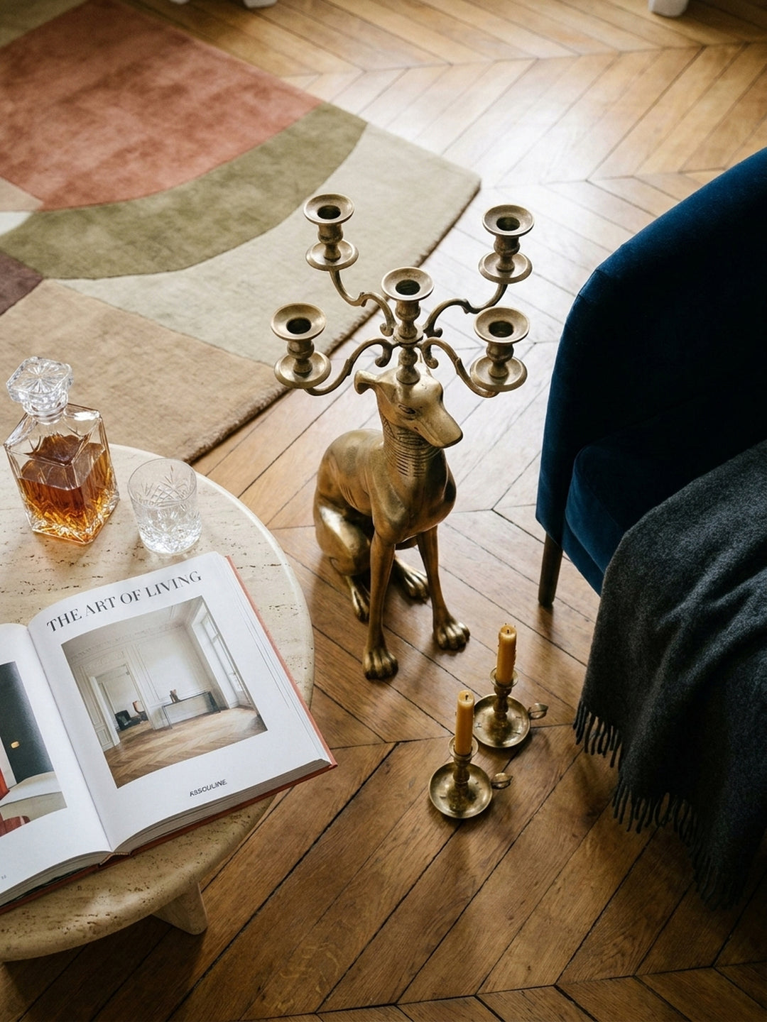 Draufsicht auf den 5-armigen Kerzenleuchter aus Aluminium in Gold, arrangiert auf einem antiken Perserteppich in einem eleganten Esszimmer._