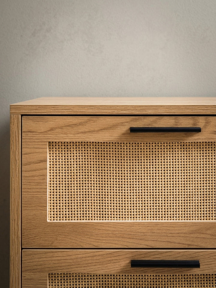 Detailaufnahme eines der schwarzen, pulverbeschichteten Metallgriffe an einer Schublade mit Rattan-Front, die die hochwertige Verarbeitung und moderne Haptik zeigt._