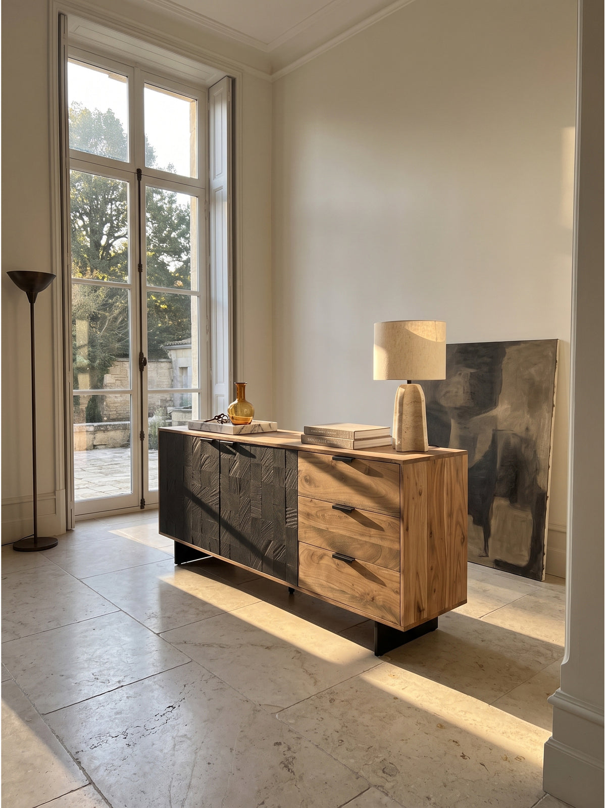 Großes Wohnzimmer im Organic-Modern Stil mit einem Sideboard aus Akazie Massivholz und dunklen 3D-Türen in Steinoptik vor einer cremeweißen Wand._