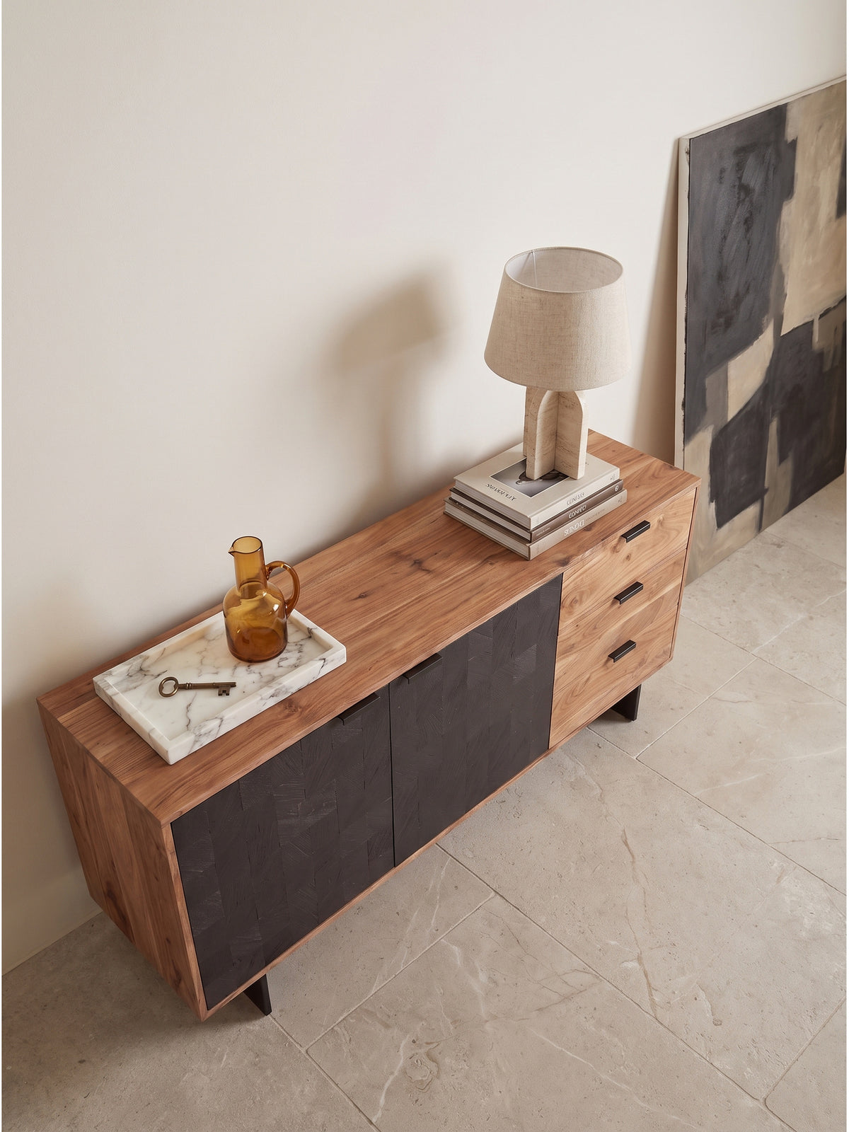 Draufsicht auf das Akazienholz-Sideboard mit Steinoptik-Türen im eleganten Wohnbereich, arrangiert auf einem handgeknüpften Vintage-Teppich._