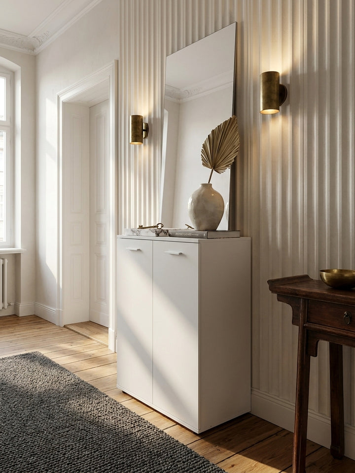 Kompakte Flurkommode neben einer eleganten Garderobe aus dunklem Holz auf einem tiefgrauen Bouclé-Teppich im luxuriösen, reduzierten Entrée_