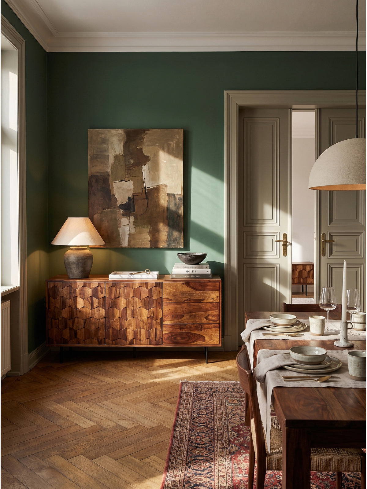 Elegantes Wohnzimmer mit einem 175 cm breiten Sideboard aus Sheesham Massivholz auf einem edlen Eichenparkett vor einer tiefgrünen Wanddekoration.