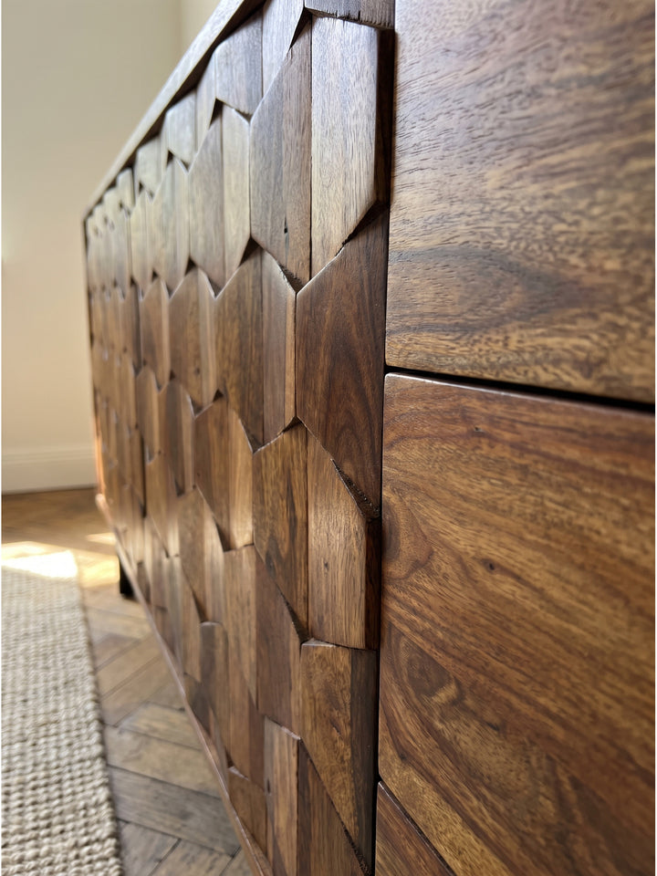 Nahaufnahme der markanten Holzmaserung und der geometrischen Oberfläche des Sheesham Sideboards, die handwerkliche Präzision im Detail zeigt._