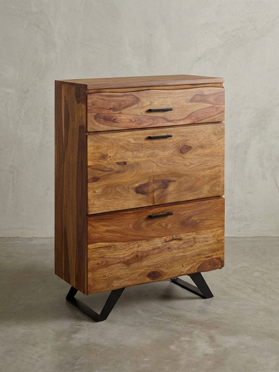 Die moderne Flurkommode aus Sheesham-Holz auf weißem Hintergrund, Frontansicht zeigt die drei Schubladen mit Baumkante und die schwarzen Metallgriffe._