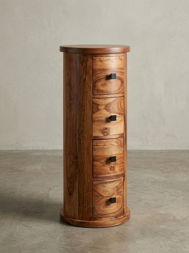 Design Beistellschrank aus massivem Sheesham-Holz in 3/4-Ansicht, die zylindrische Form und die geschwungenen Schubladenfronten zeigend._