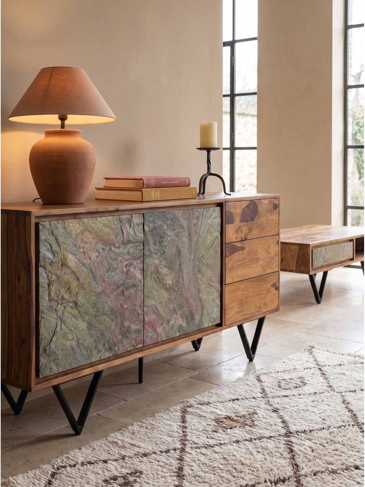 Rustikales Sideboard mit Terrakotta Tischleuchte dekoriert und massiven Eisenbeinen im gemütlichen Wohnbereich mit warmem Licht