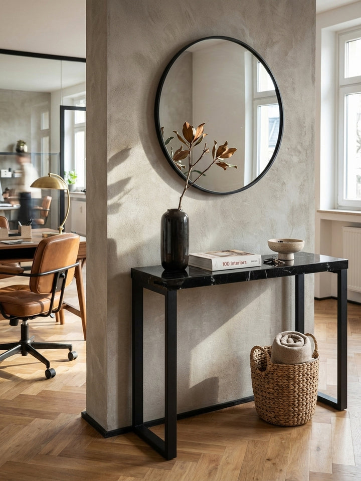 Der lange Konsolentisch mit schwarzen Metallbeinen als Teil eines modernen Eingangsbereichs, kombiniert mit einem bunten Teppich und einer großen Zimmerpflanze._