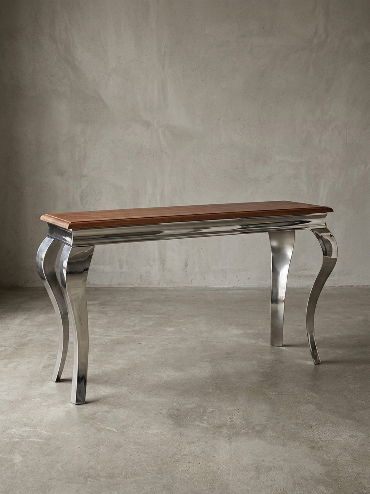 Moderner Konsolentisch freigestellt in der Frontalansicht. Die 130x76 cm große Anrichte kombiniert eine massive Echtholzplatte mit vier glänzenden, barock geschwungenen Metallbeinen._
