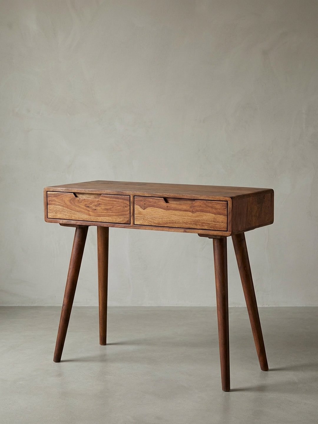 Vorderansicht des modernen Konsolentischs aus Sheesham Massivholz. Der kompakte Schreibtisch 90x76x36cm zeigt zwei Schubladen mit Griffmulden und konisch zulaufende Retro-Beine._