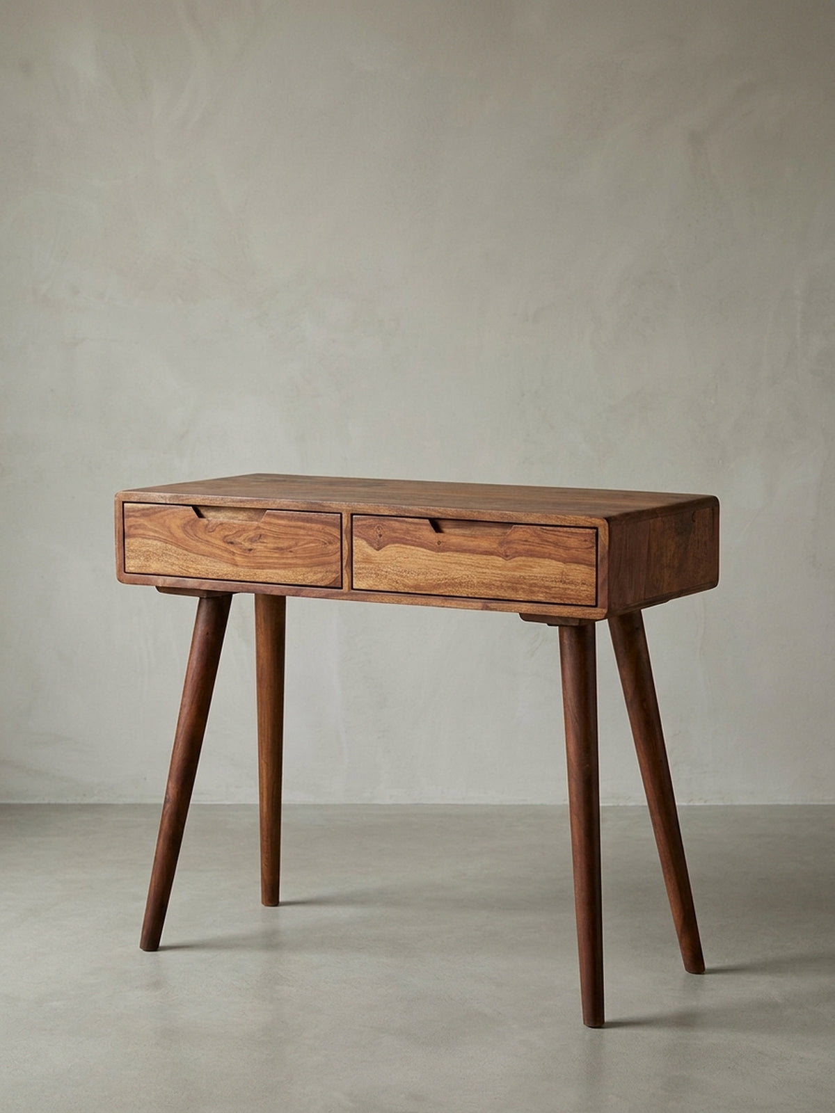 Vorderansicht des modernen Konsolentischs aus Sheesham Massivholz. Der kompakte Schreibtisch 90x76x36cm zeigt zwei Schubladen mit Griffmulden und konisch zulaufende Retro-Beine._