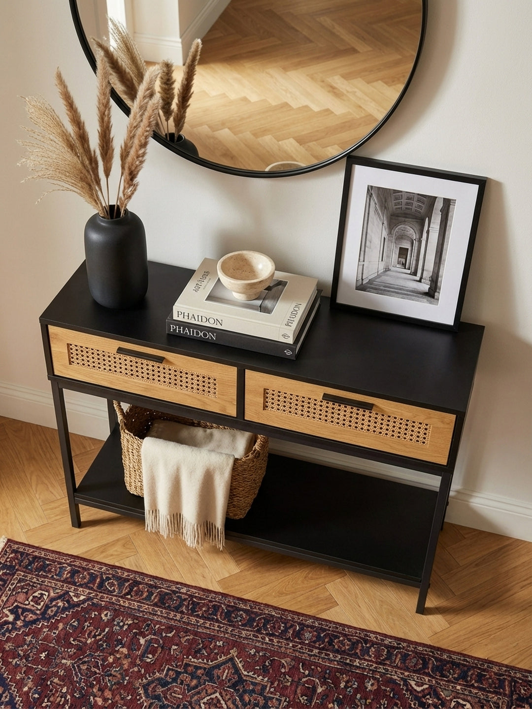 Draufsicht auf den schmalen Dielentisch mit Rattanschubladen, dekoriert mit Lampe und Vase, in einem modernen Eingangsbereich._